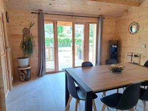 a dining room with a wooden table and chairs at Chalet au cœur d'un domaine in Marcilly-sur-Eure