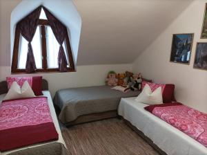 a bedroom with two beds and a window at Krisztinusz Vendégház in Fonyód