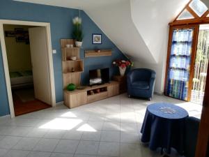 a living room with a chair and a table at Krisztinusz Vendégház in Fonyód