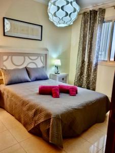 ein Schlafzimmer mit einem großen Bett mit roten Kissen darauf in der Unterkunft Apartamento Las Palmeritas Palm Mar Tenerife Sur in Palm-mar + 54 Fotos