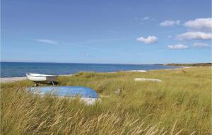 a boat sitting in the grass next to the ocean at Holiday Home Ingerslevvej Gørlev Vi in Gørlev
