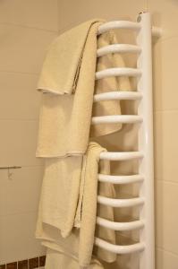 - une pile de serviettes sur un porte-serviettes dans la salle de bains dans l'établissement Zagłoba Karczma, à Carolinensiel