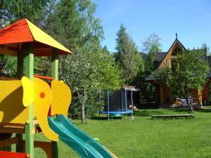 un parque infantil con un tobogán en un patio con una casa en Jędruś, en Zakopane