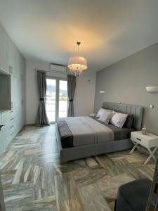 a bedroom with a large bed and a chandelier at Zandre Luxury Suites in Skiros