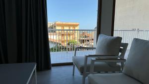 a living room with a chair and a large window at Marina di Modica - Via del Laghetto in Marina di Modica +6 photos
