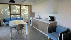 a kitchen with a table and blue chairs and a sink at Marina di Modica - Via del Laghetto in Marina di Modica
