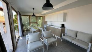 a kitchen with white chairs and a table and a counter at Marina di Modica - Via del Laghetto in Marina di Modica