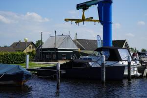 a small boat docked at a dock with a plane at EuroParcs Kagerplassen in Warmond