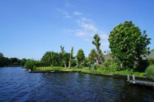 a river with a dock and trees on the side at EuroParcs Kagerplassen in Warmond