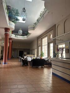 a lobby with tables and chairs in a building at Puente del Rey in El Rocío