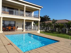 a swimming pool in front of a house at Apartment Chianti's in Port Edward
