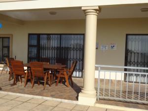 a wooden table and chairs in a building with a column at Apartment Chianti's in Port Edward