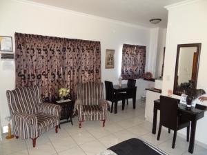 a living room with two chairs and a piano at Apartment Chianti's in Port Edward