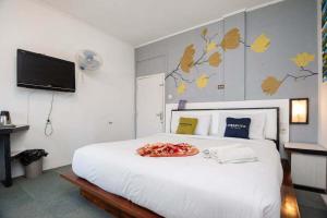 a bedroom with a large white bed with a plate on it at Urbanview Hotel Ananda Syariah by RedDoorz in Bukittinggi