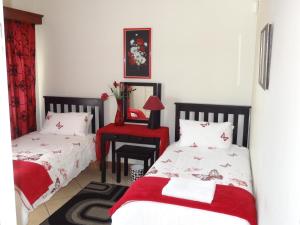 a bedroom with two beds and a table with a chair at Apartment Chianti's in Port Edward