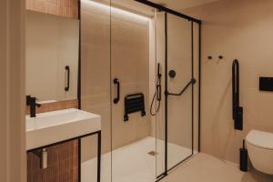a bathroom with a shower and a sink and a toilet at Pau Suites in Villajoyosa