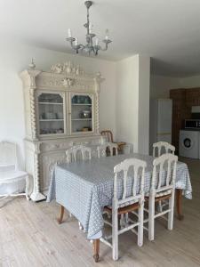 ein Esszimmer mit Tisch und Stühlen und einem Kronleuchter in der Unterkunft La maison du Verger in Brinon-sur-Sauldre + 21 Fotos