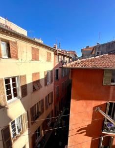een uitzicht over een steeg tussen twee gebouwen bij Collet Résidence in Nice