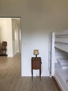 ein Schlafzimmer mit einem Bett und einem Tisch mit einer Lampe in der Unterkunft La maison du Verger in Brinon-sur-Sauldre