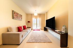 un salon avec un canapé et une télévision à écran plat dans l'établissement Baleal Deluxe Apartments, à Baleal