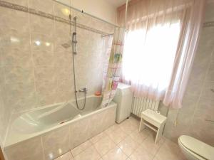 a bathroom with a tub and a toilet at Bright Apartment 300 m from sea in Grottammare