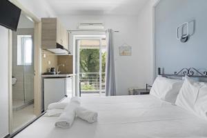 a bedroom with a white bed with towels on it at Iguana studio 7 in Preveza