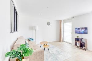 a living room with a couch and a table at Bord de Marne, proche Disneyland et Paris Gare à 2 min in Thorigny-sur-Marne