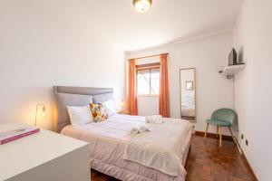 ein kleines Schlafzimmer mit einem Bett und einem Stuhl in der Unterkunft Baía - by Smarthomes in São Martinho do Porto + 23 Fotos