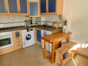 a kitchen with a table and a washing machine at Piso RoSa in L'Ampolla