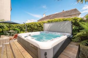 a jacuzzi tub sitting on top of a patio at Grande maison-Marché-10pers-jacuzzi-parking in Dinard