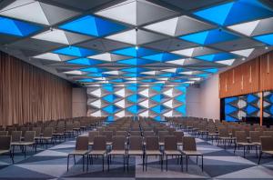 ein großes Zimmer mit Sitzreihen und einer Bühne in der Unterkunft Andaz Munich Schwabinger Tor, By Hyatt in München + 37 Fotos