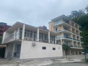 a white building with balconies on the side of it at SUNSHINE Hotel Kvariati in Kvariati