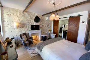 a bedroom with a bed and a tv and a fireplace at La Sanverine private room historic center Vence in Vence