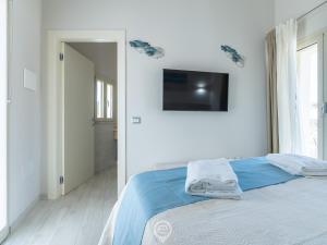 Un dormitorio con una cama y un televisor en la pared. en Il Ginepro, en Pula 17 fotos más