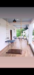 a living room with a swing and a table at Saanvi Farmhouse in Hampi