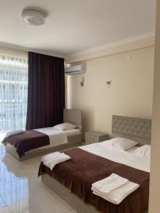 Rúm í herbergi á SUNSHINE Hotel Kvariati