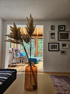 a vase with a plant on a table in a living room at Black Lake Chalet-300m from Black Lake,Durmitor in Žabljak