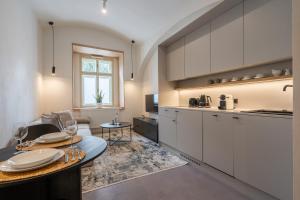 a kitchen with white cabinets and a table with wine glasses at HONEST Karlin in Prague