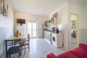 a kitchen and living room with a table and a washing machine at Appartamento Fronte Mare in Marina di Strongoli