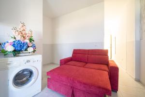 a red couch sitting next to a washing machine at Appartamento Fronte Mare in Marina di Strongoli