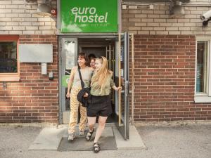 two women walking into a door of a building at Eurohostel in Helsinki
