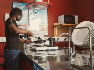 a man cooking in a stove in a kitchen at Eurohostel in Helsinki
