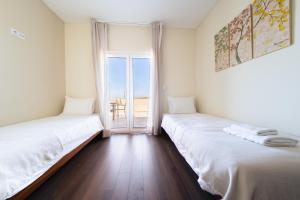 deux lits dans une chambre avec vue sur l'océan dans l'établissement Baleal Deluxe Apartments, à Baleal 45 autres photos