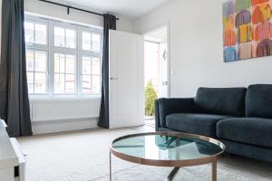 a living room with a couch and a glass table at 3 Bedroom 4 Bathroom House Goodwood Chichester in Chichester