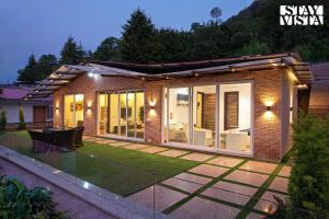 a small house with a garden at night at StayVista at Suri Ville with Heater & Mountain View in Bhīm Tāl