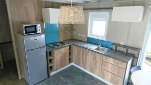 a small kitchen with a refrigerator and a microwave at Camping White Rock in Castellane