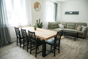 salon ze stołem, krzesłami i kanapą w obiekcie Apartmány paní poštmistrové w mieście Loučná nad Desnou