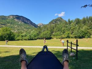 a person laying on the grass looking at a girl in a field at Camping White Rock in Castellane