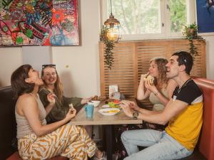 a group of people sitting at a table eating food at Eurohostel in Helsinki