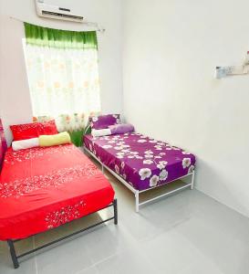亚娄Homestay Amir Chemumaq的有两张床和一扇窗户的卧室